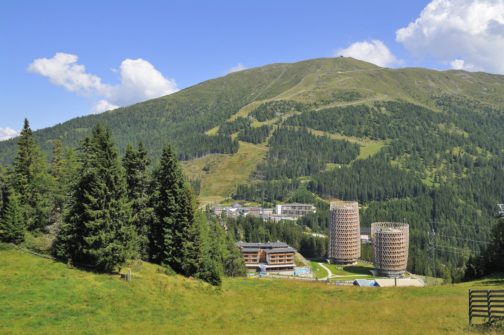 Der Falkensteiner Club Funimation Katschberg mit den beiden runden Hoteltürmen und einem extra Hotelgebäude in mitten einer großen Berglandschaft