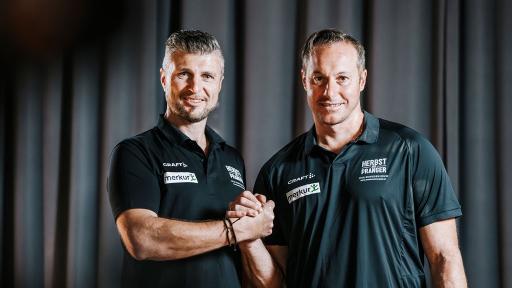 Reinfried Herbst und Manfred Pranger stehen mit verschränkten Händen nebeneinander